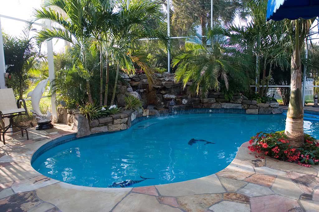 Lagoon pool remodel with natural stone waterfalls and flagstone deck designed and built by Lucas Lagoons Inc. in Bradenton, FL