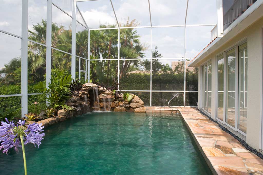 Lagoon pool remodel with two waterfalls, flagstone decking and landscape beds designed and built by Lucas Lagoons Inc on Longboat Key, FL.