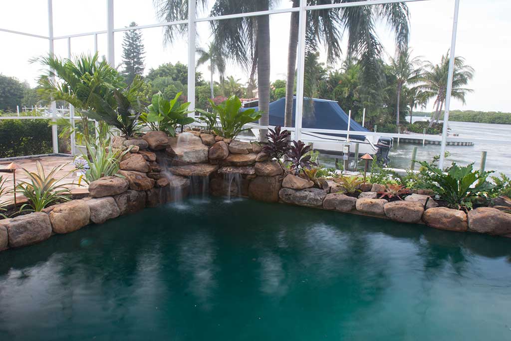 Lagoon pool remodel with two waterfalls, flagstone decking and landscape beds designed and built by Lucas Lagoons Inc on Longboat Key, FL.