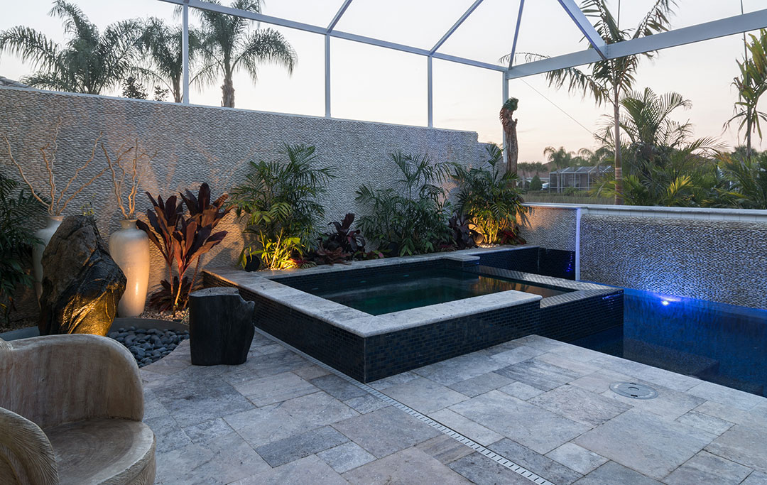 Modern pool/spa and waterwall with outdoor kitchen. Perfect for parties and designed by Lucas Lagoons for the series Insane Pools on Animal Planet