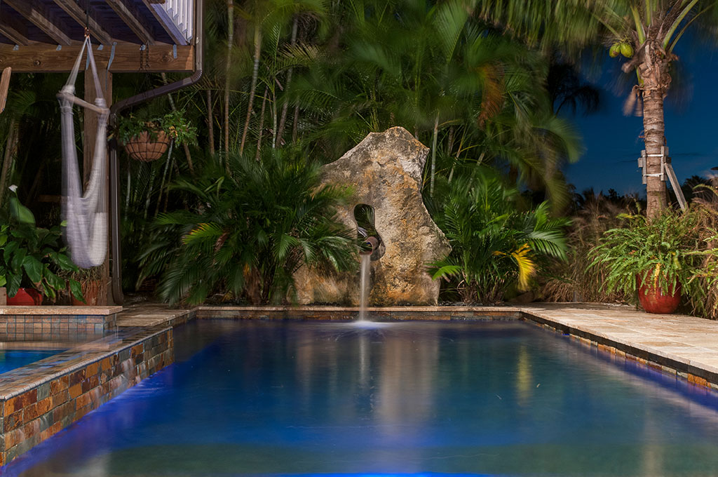 Modern Zen Pool and spa with copper scupper coming out of Limestone boulder designed and built by Lucas Lagoons Inc.