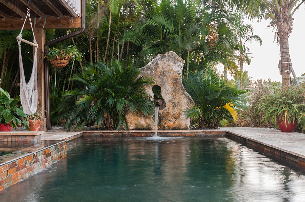 Modern Zen Pool and spa with copper scupper coming out of Limestone boulder designed and built by Lucas Lagoons Inc.