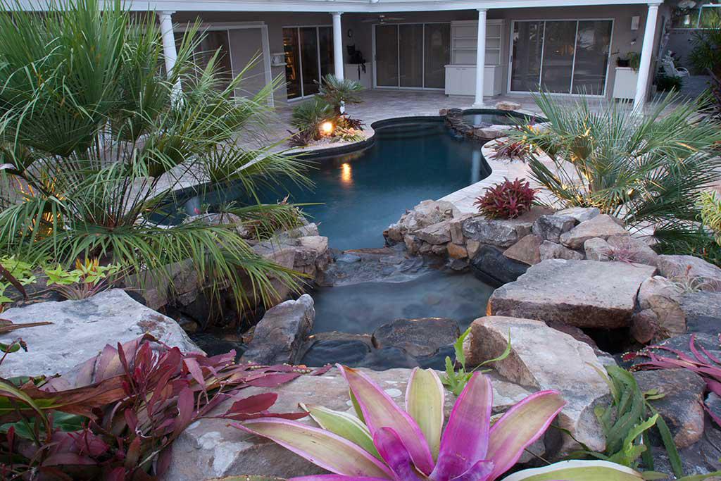 Lagoon Pool remodeled by changing shape of swimming pool from linear to naturally curving lagoons style and adding spa and waterfall and planters designed and built in Osprey, Florida by Lucas Lagoons Inc.