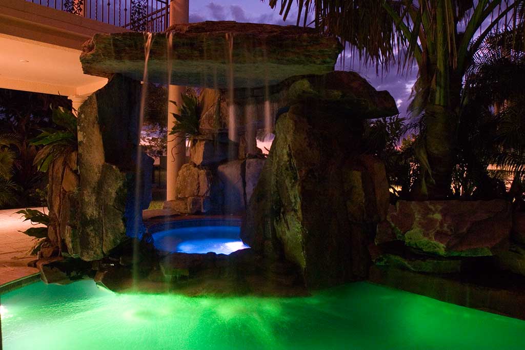 Lagoon pool with spa underneath natural Tennessee Fieldstone grotto waterfall, Siesta Key, Florida designed and built by Lucas Lagoons Inc.