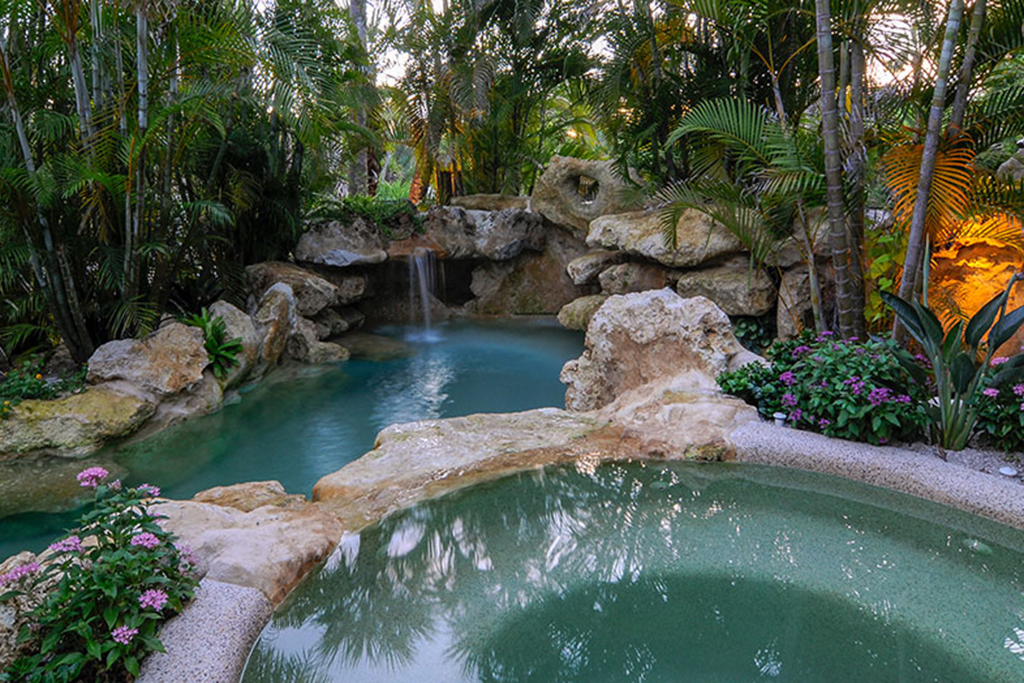 Palm Island lagoon and spa with Florida Limestone waterfalls and Grottos and tropical landscaping