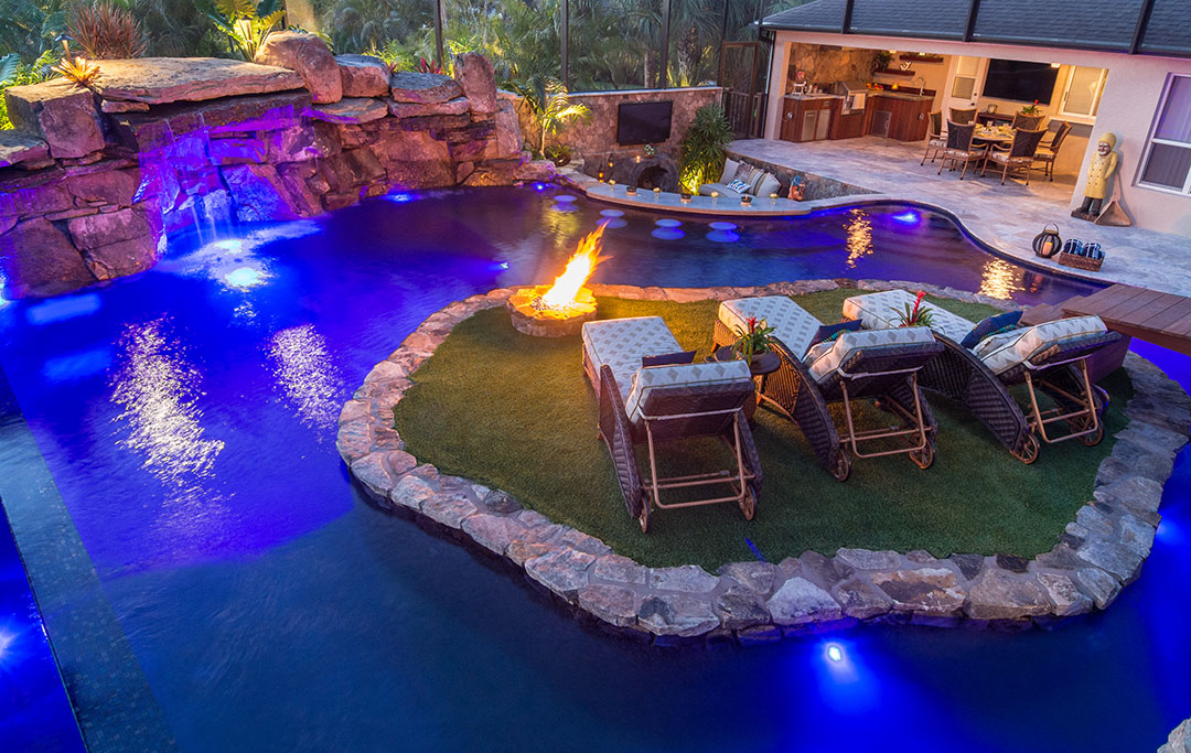 A Lazy River around an island with a fire feature in a Lagoon Pool with Infinity edge and Natural Stone Waterfalls designed and built by Lucas Lagoons Inc for the series Insane Pools on Animal Planet