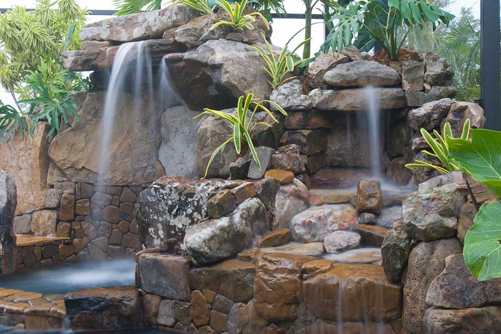 Lagoon swimming pool remodel with rock waterfall and coping by Lucas Lagoons Inc.