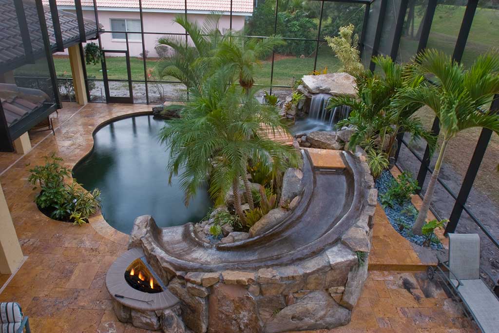 Lagoon swimming pool remodel with added pool, bridge and slide by Lucas Lagoons Inc.