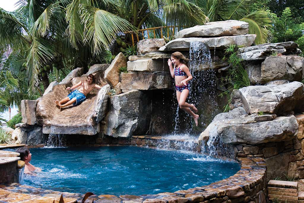 Lagoon Pool renovation with large stone grotto of Tennessee Fieldstone and slide designed and built in Osprey Florida by Lucas Lagoons Inc.